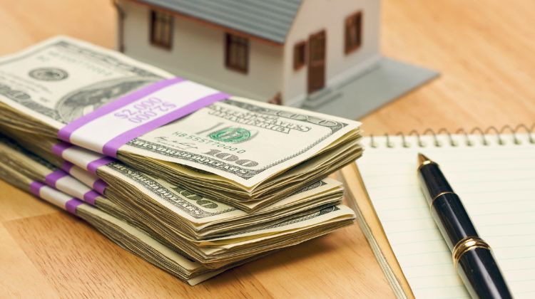 stack of $100 bills symbolizing a down payment for a house