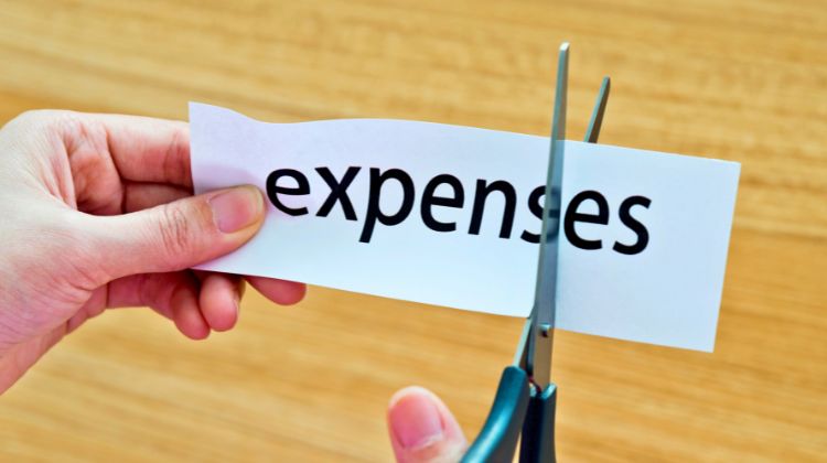 cutting piece of paper that says expenses