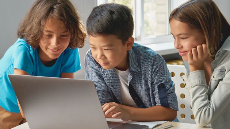 three kids learning on a laptop