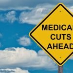 street sign that says "medicaid cuts ahead"