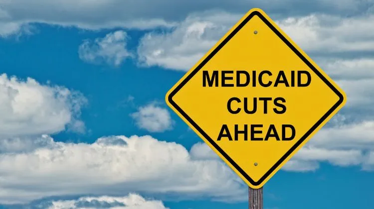 street sign that says "medicaid cuts ahead"