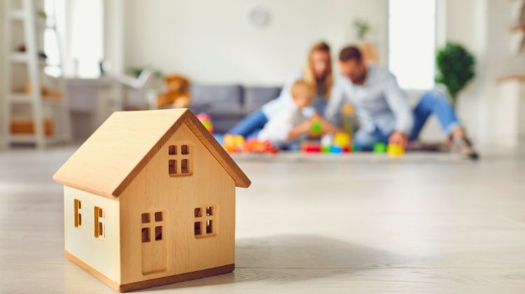 family sitting in living room playing with their young child
