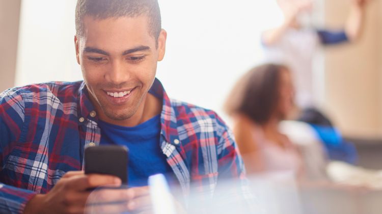 young man looking at checking account information on his phone